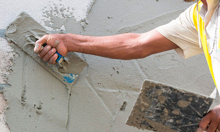 Мужчина штукатурит стены