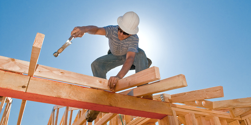 A carpenter installing roof trusses